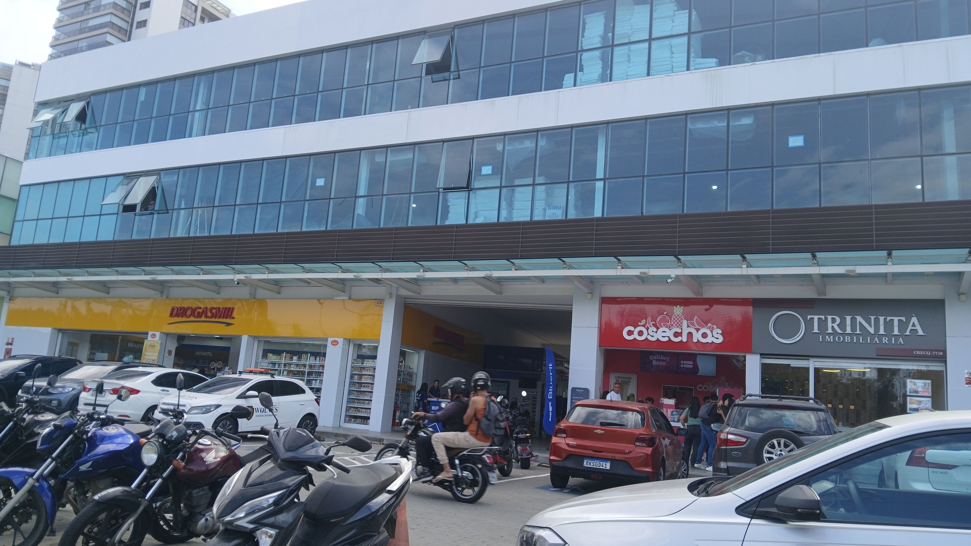 A commercial building with multiple storefronts, including a gas station, a food market, and an immovable property company.