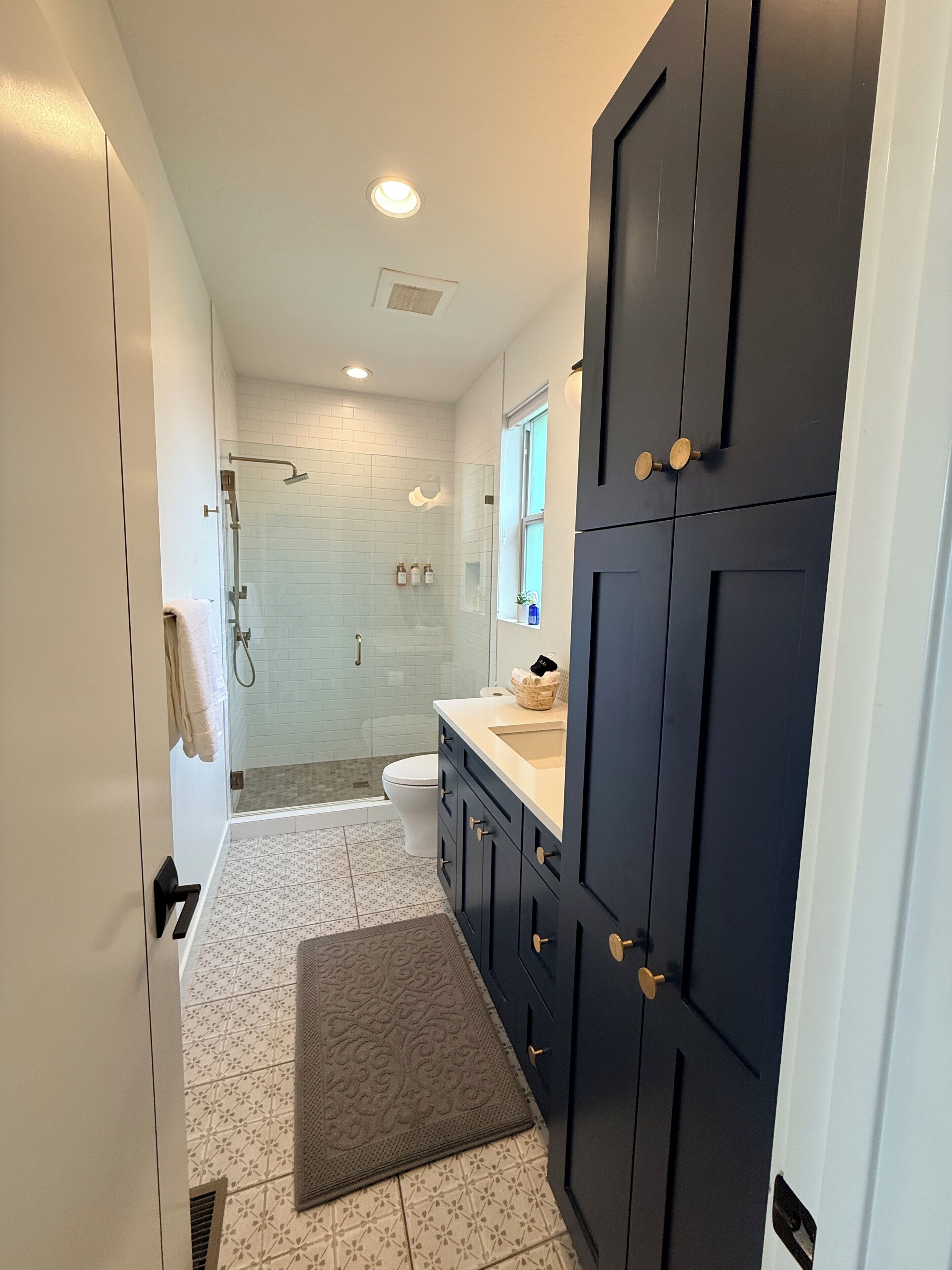 A modern bathroom with a shower, toilet, and vanity.