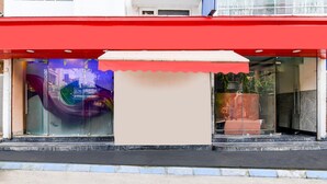 A storefront with a red awning, large glass windows, and a visible entrance. - Deluxe Room Aspiring Inn (Kolkata)