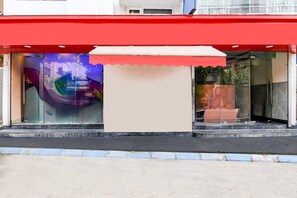 En butik med rødt markise, store glasruder og en tydelig indgang.