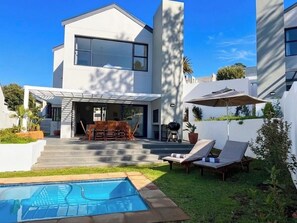 A modern two-story house with a swimming pool, outdoor seating, and a covered patio area. - Villa acrewood (Cape Town)