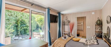 Un dormitorio con una cama, un escritorio y vistas al exterior.