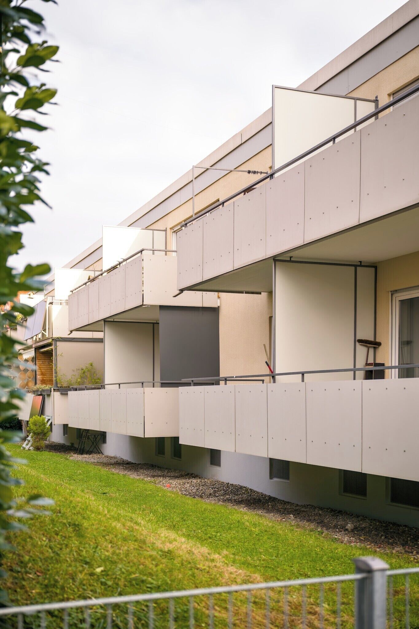 Ein modernes Gebäude mit mehreren Balkonen und großen Fenstern.