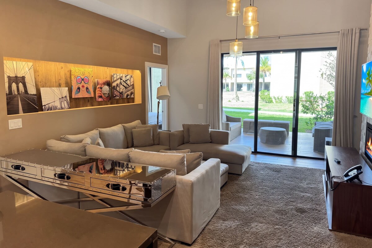 A modern living room with a sectional sofa, a coffee table, and artwork on the wall.
