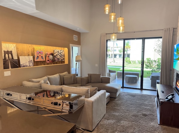 A modern living room with a sectional sofa, a coffee table, and artwork on the wall.