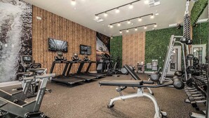 A gym with treadmills, stationary bikes, and weight machines. - Magic Village Paradise 4BR (Kissimmee)