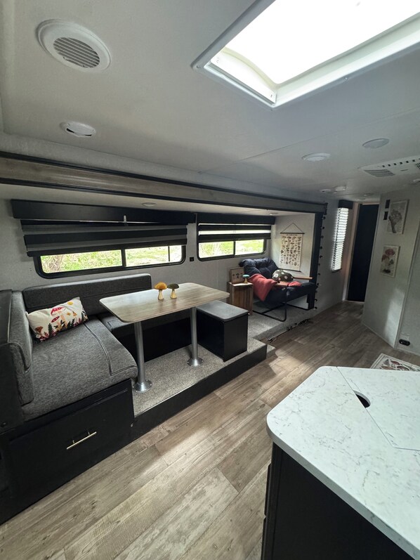 A compact interior with a dining area, a sofa, and a kitchen counter.