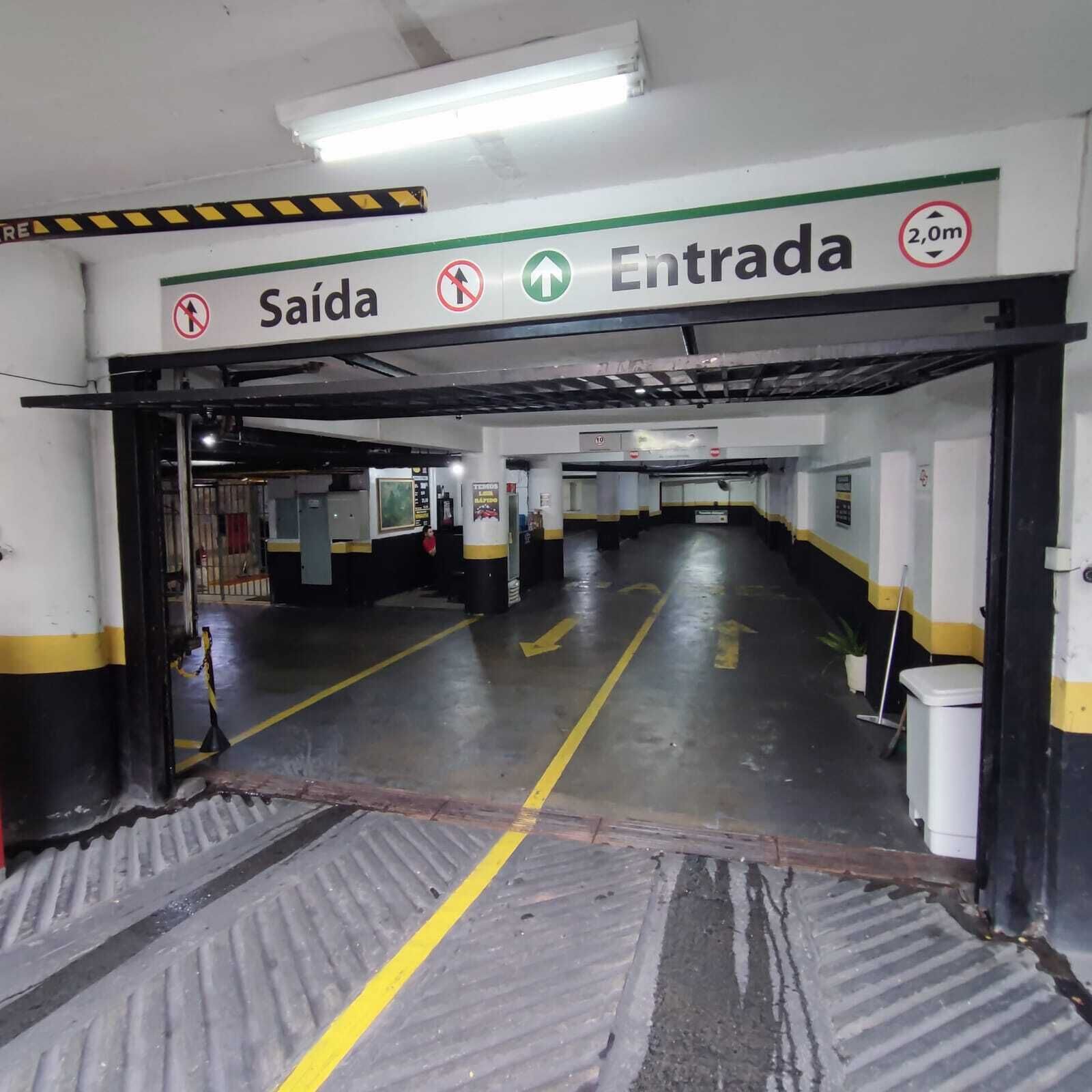 A parking garage entrance with directional arrows, a 'Salida' sign, and a '2,0m' height restriction sign.