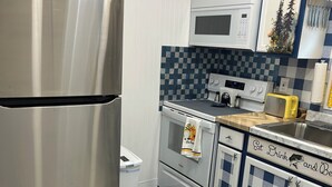 Eine moderne Küche mit Edelstahlgeräten, einer Mikrowelle und karierten Schränken.