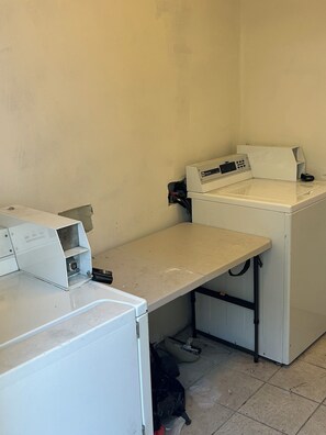 A laundry room with a washing machine, a dryer, and a utility sink. - A Charming Apartment inDTLA (Los Angeles)
