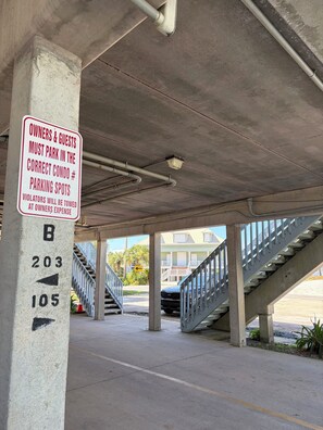 Un parking avec un panneau indiquant les places de stationnement réservées aux propriétaires et à leurs invités.