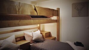 Ein Etagenbett mit Holz Kopfteil, einem Nachttisch und einem Wandbild.