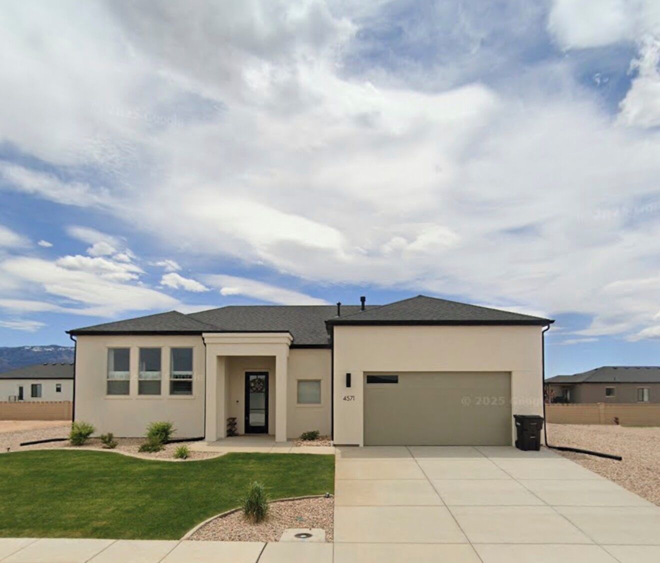 A single-story house with a garage, a front lawn, and a clear sky.