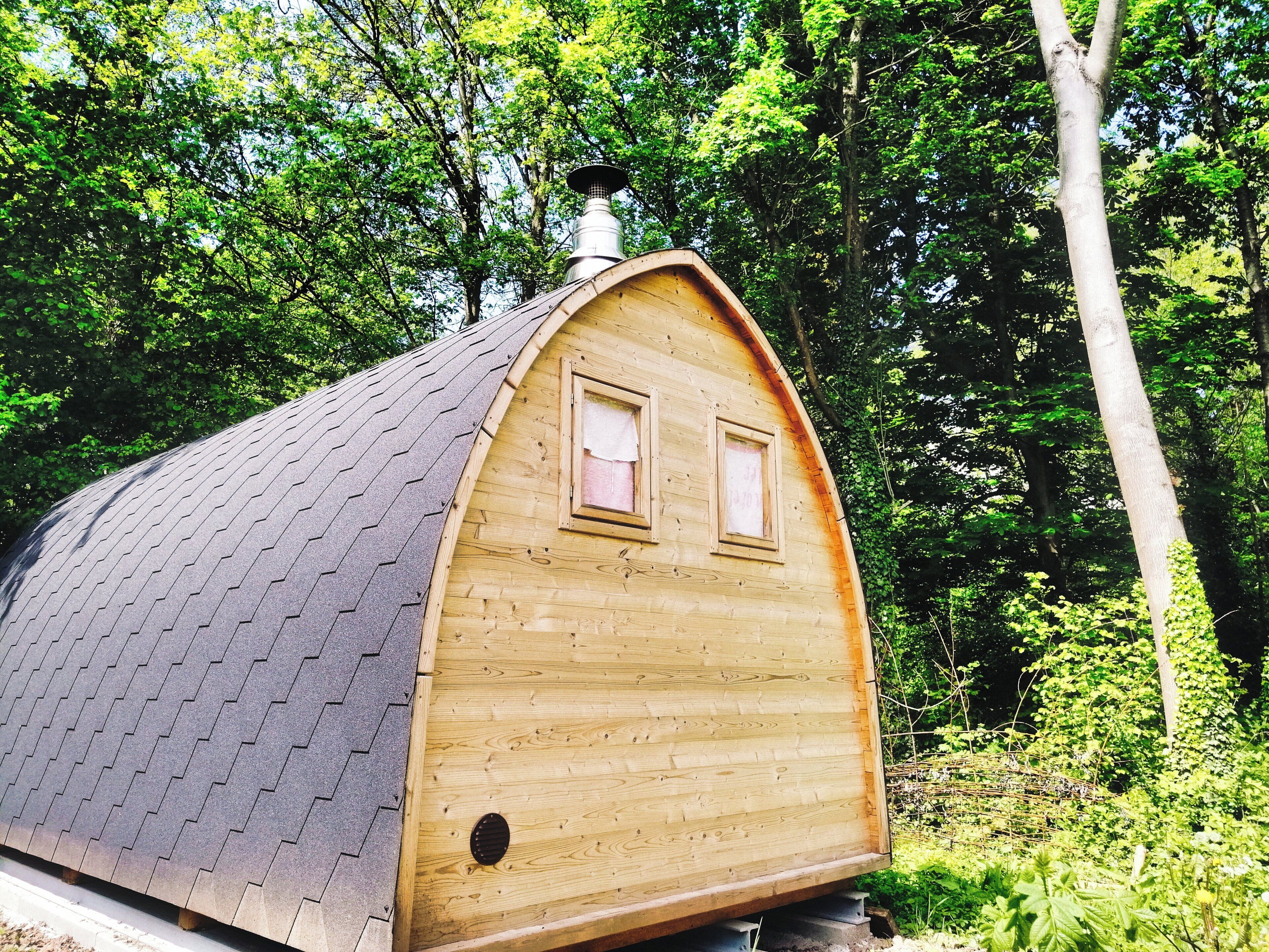 A wooden cabin with a sloped roof, two windows, and a chimney.