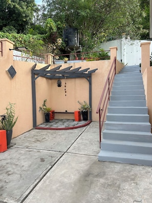 A concrete staircase leading up to a building entrance with a pergola and potted plants. - Belle Escape - Blue Room (Castries)