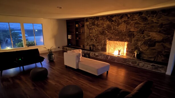 Una sala de estar con chimenea de piedra, un sofá, un banco y una mesa de centro.