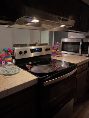 A kitchen with a stove, microwave, and cabinets. - Japanese garden estate in Monterey Count on a 40 acre ranch (Salinas)