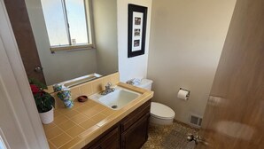 Un baño con lavamanos, inodoro y ventana.