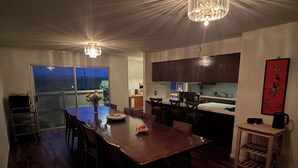 Una cocina moderna con comedor, suelo de madera y una araña.