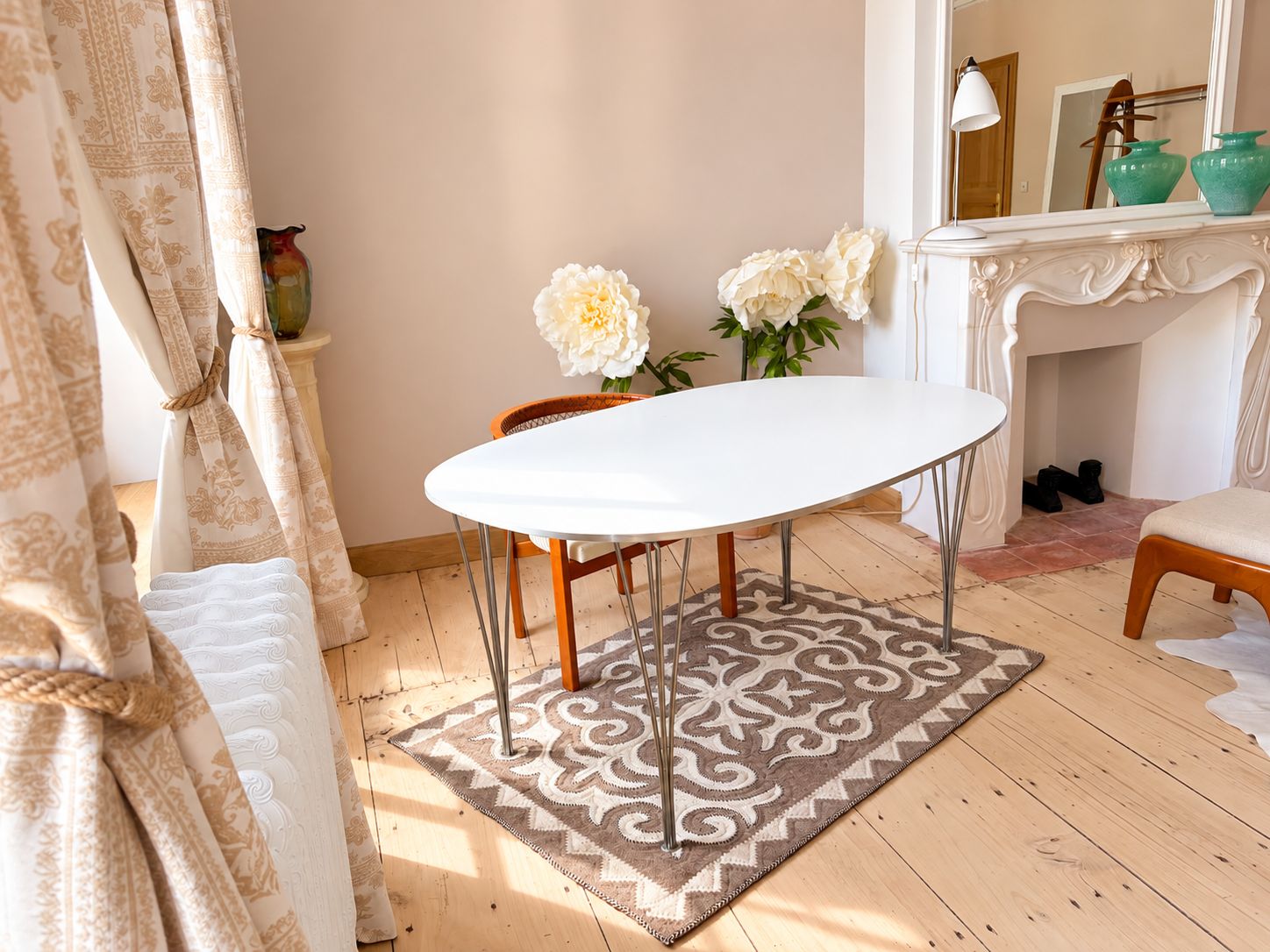 Una habitación con una mesa blanca, un tapete estampado y una silla.