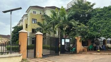 A gated residential area with a paved entrance, a solar street light, and a security guard.