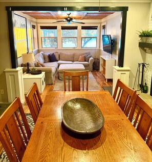 A dining area with a wooden table, chairs, and a large decorative bowl in the center.