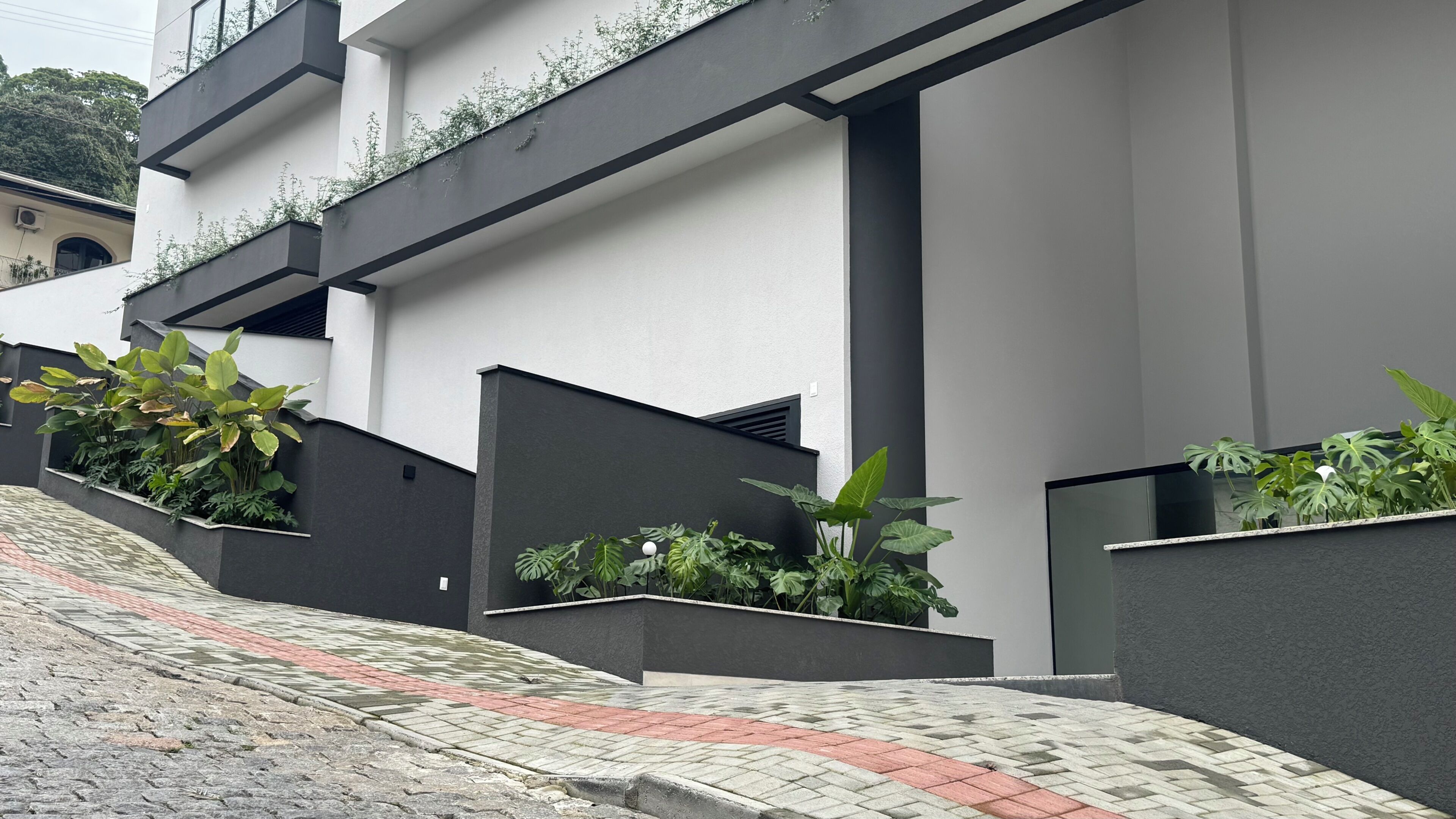 A modern building with a flat roof, a staircase, and a pathway.