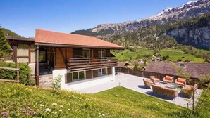 Une maison moderne dotée d’un balcon donnant sur un paysage montagneux.