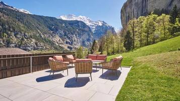 A patio with outdoor furniture and a mountain view.