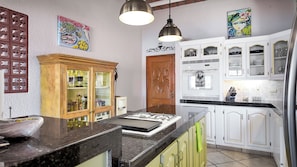 Eine Küche mit Gasherd, Holzschränken und einem Kühlschrank.