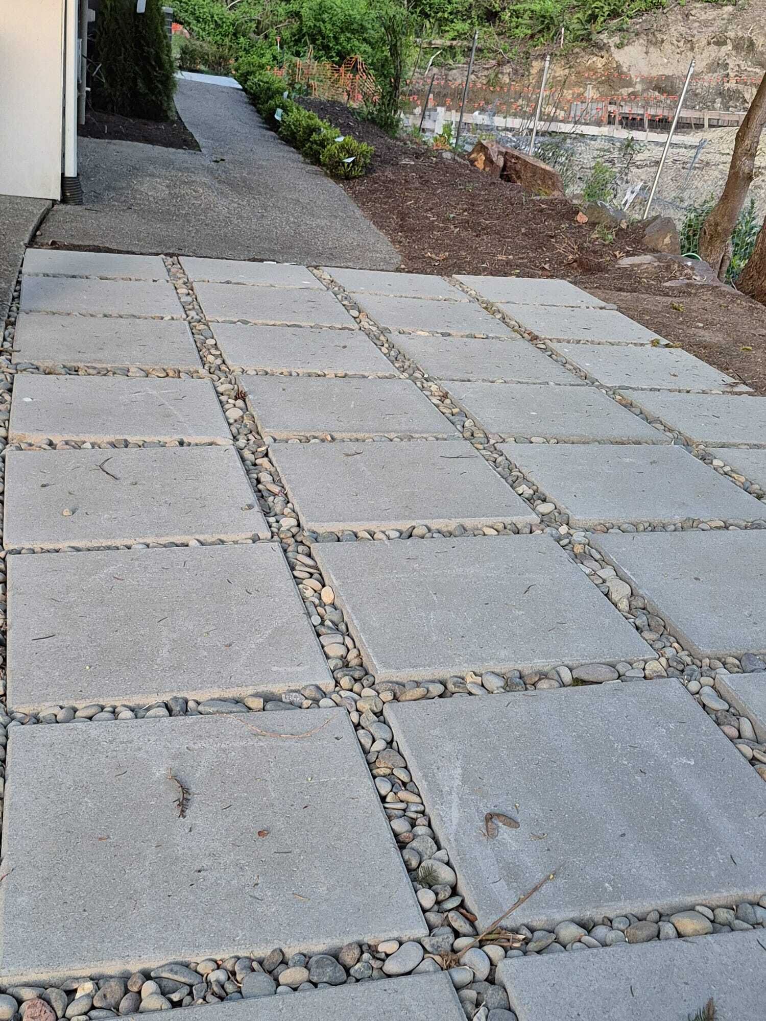 A paved walkway with stone slabs and a pebble border.