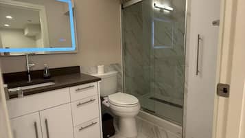 Une salle de bain moderne équipée de toilettes, d’un lavabo et d’un espace douche.