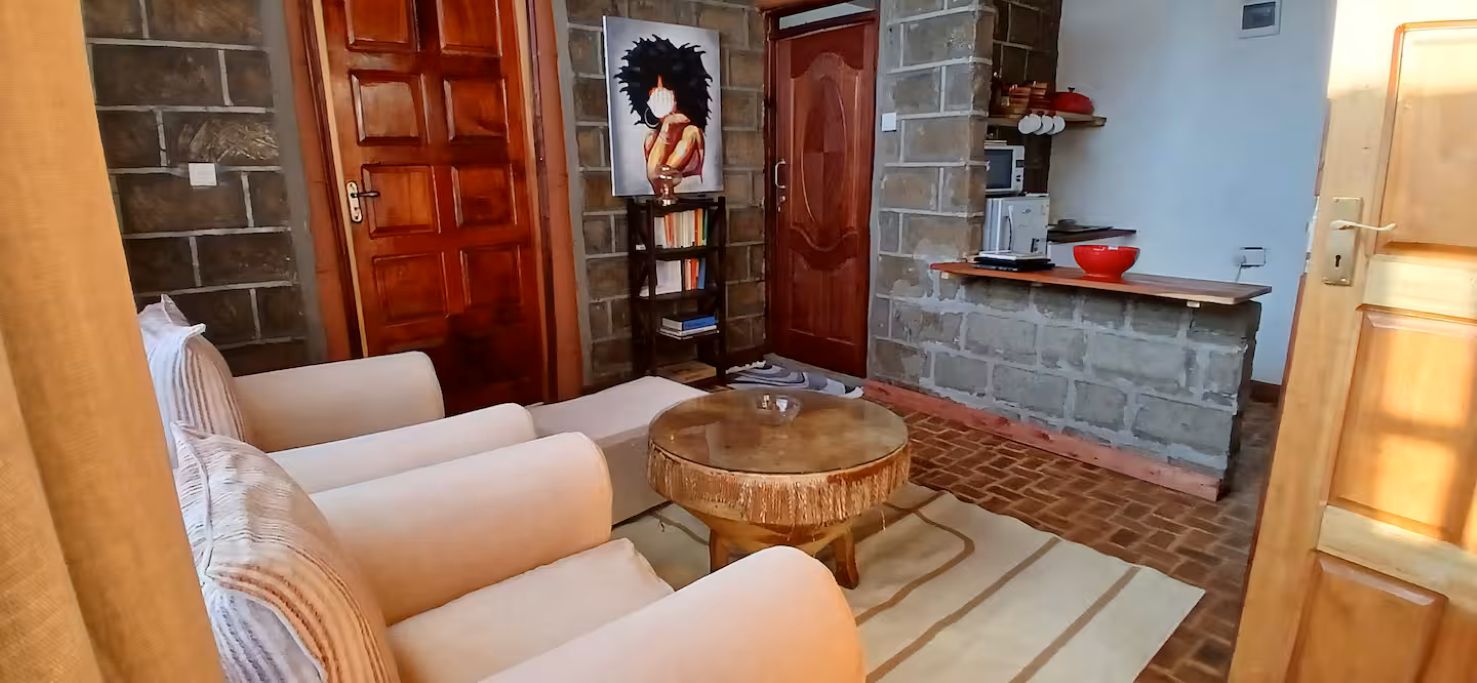 A cozy room with a sofa, a round wooden table, and a bookshelf.