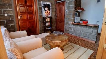 A cozy room with a sofa, a round wooden table, and a bookshelf.