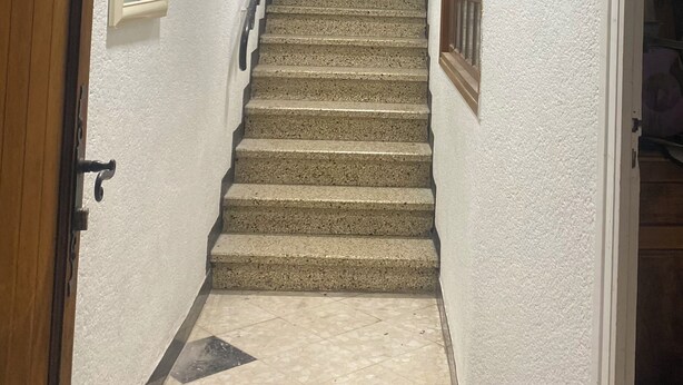 A staircase with a handrail, a door on the left, and a window on the right. - Vrbo Property (Caudiès-de-Fenouillèdes)