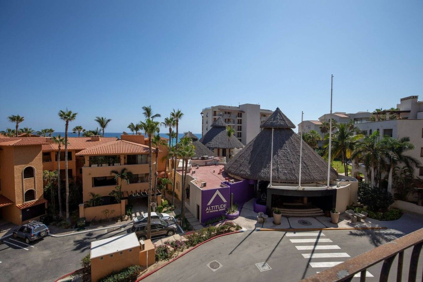 Un complexe hôtelier doté d’une piscine, de palmiers et offrant une vue sur l’océan.
