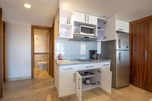 A compact kitchen with a microwave, coffee maker, and a refrigerator. - Depto. a 5 min del mar y el centro de San Jose 106 (San José del Cabo)