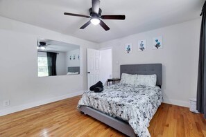 A bedroom with a bed, a ceiling fan, a window, and a door. - Ultimate Pocono Getaway  HotTub•Theater•GameRoom (Tunkhannock Township)