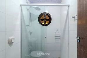 Eine begehbare, gläserne Dusche mit modernem Design, einer sichtbaren Duschbrause und einem Handtuchhalter.