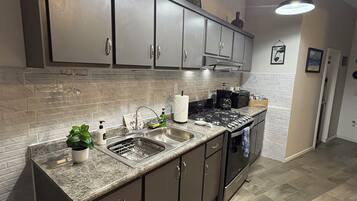 A modern kitchen with granite countertops, stainless steel appliances, and a backsplash.