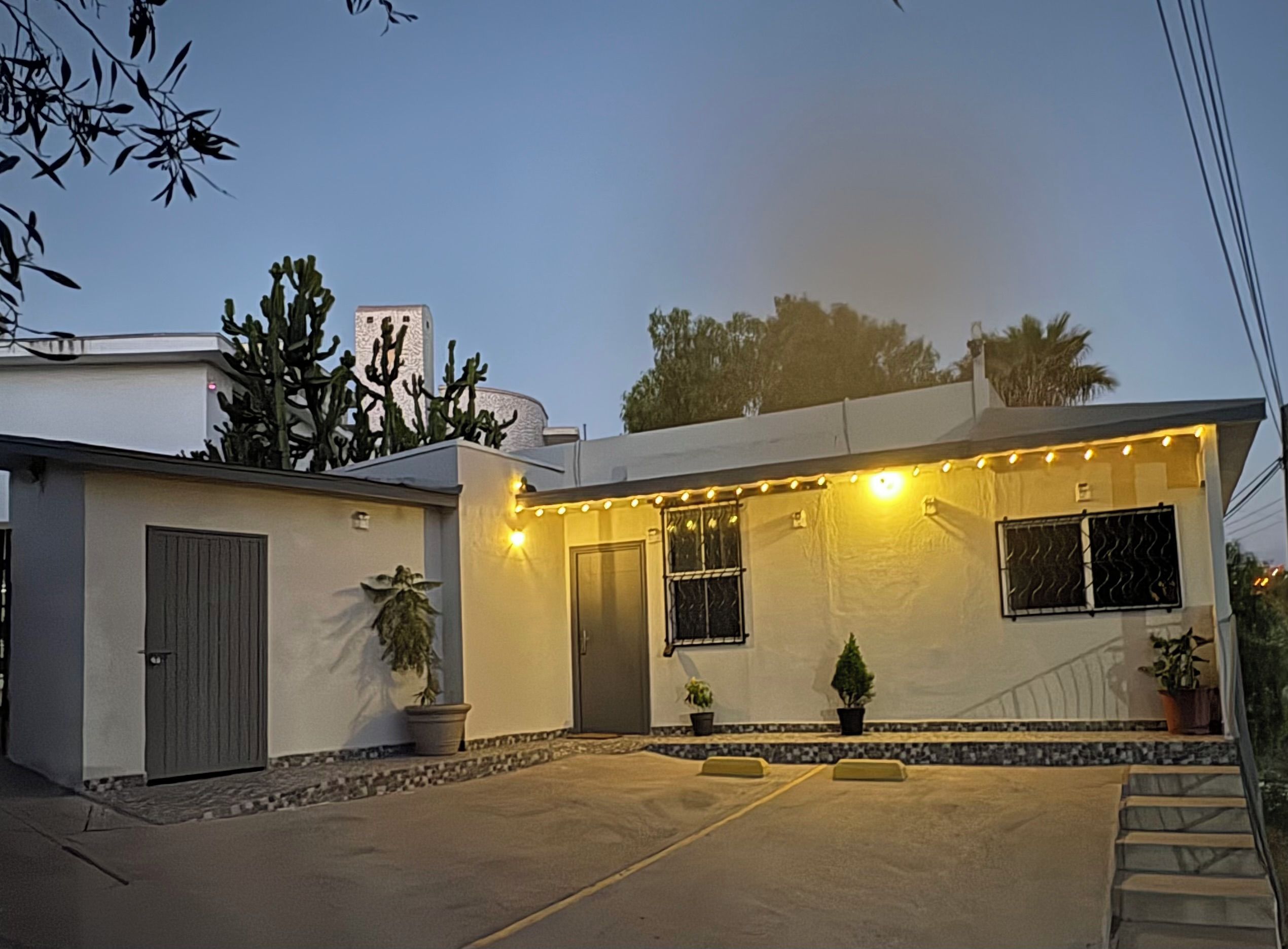 A residential building with a garage, a covered patio area, and a staircase leading to the entrance.