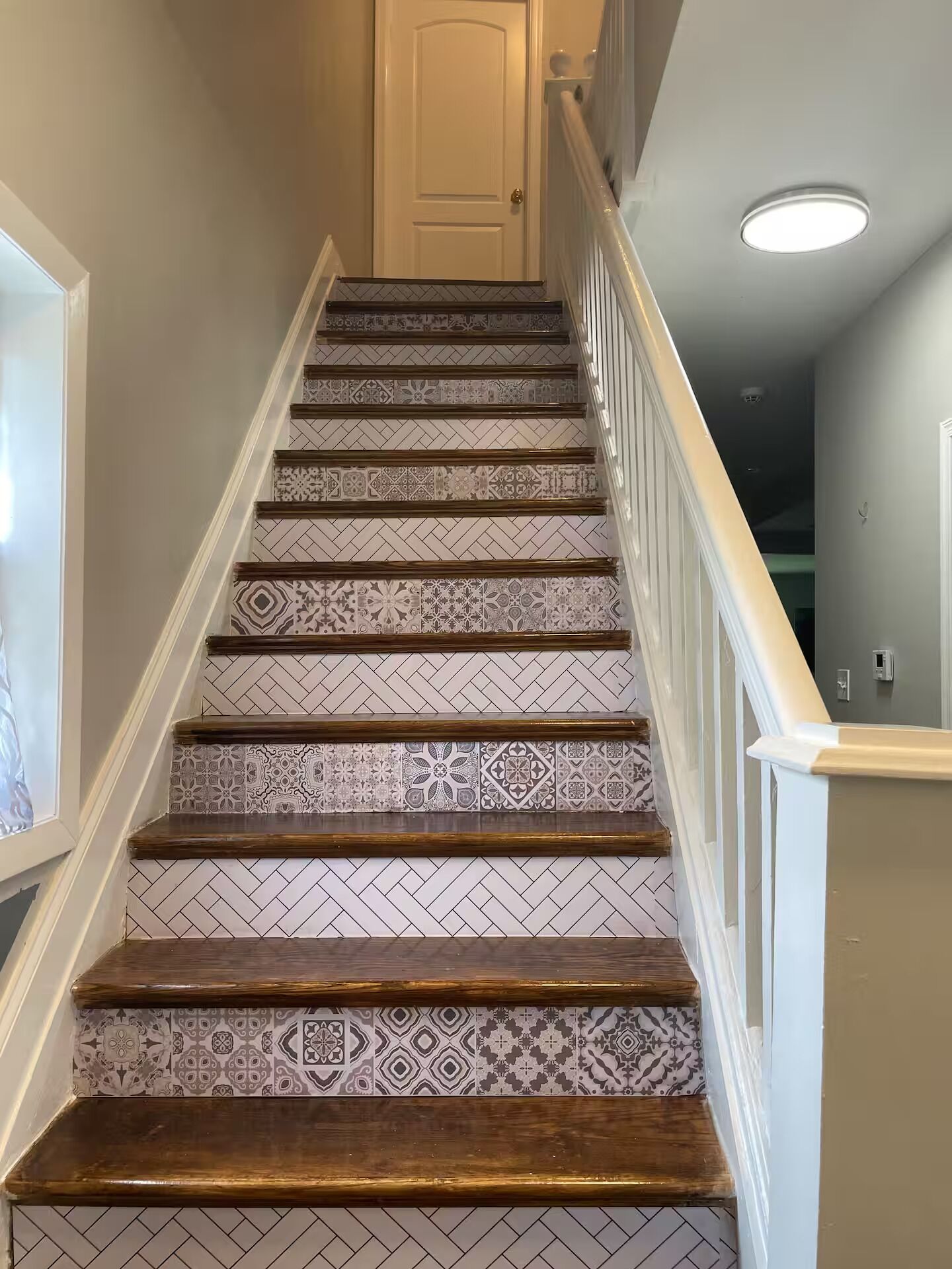 A staircase with patterned tiles and wooden steps.