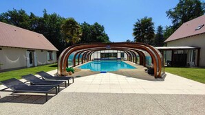 A swimming pool with a covered area, lounge chairs, and a building with a tiled roof. - Domaine Sylvaria - Bed and Breakfast - Figuier Room (sleeps 8) Nature/Peace and Quiet/Swimming Pool (Lassay-sur-Croisne)