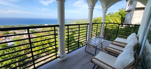 A balcony with a view of the sea, furnished with wicker chairs and a glass table. - Seaview property near Ocho Rios and Ian Fleming airport (Salt Gut)