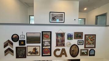 A wall with various framed pictures and a large 'CA' sign.