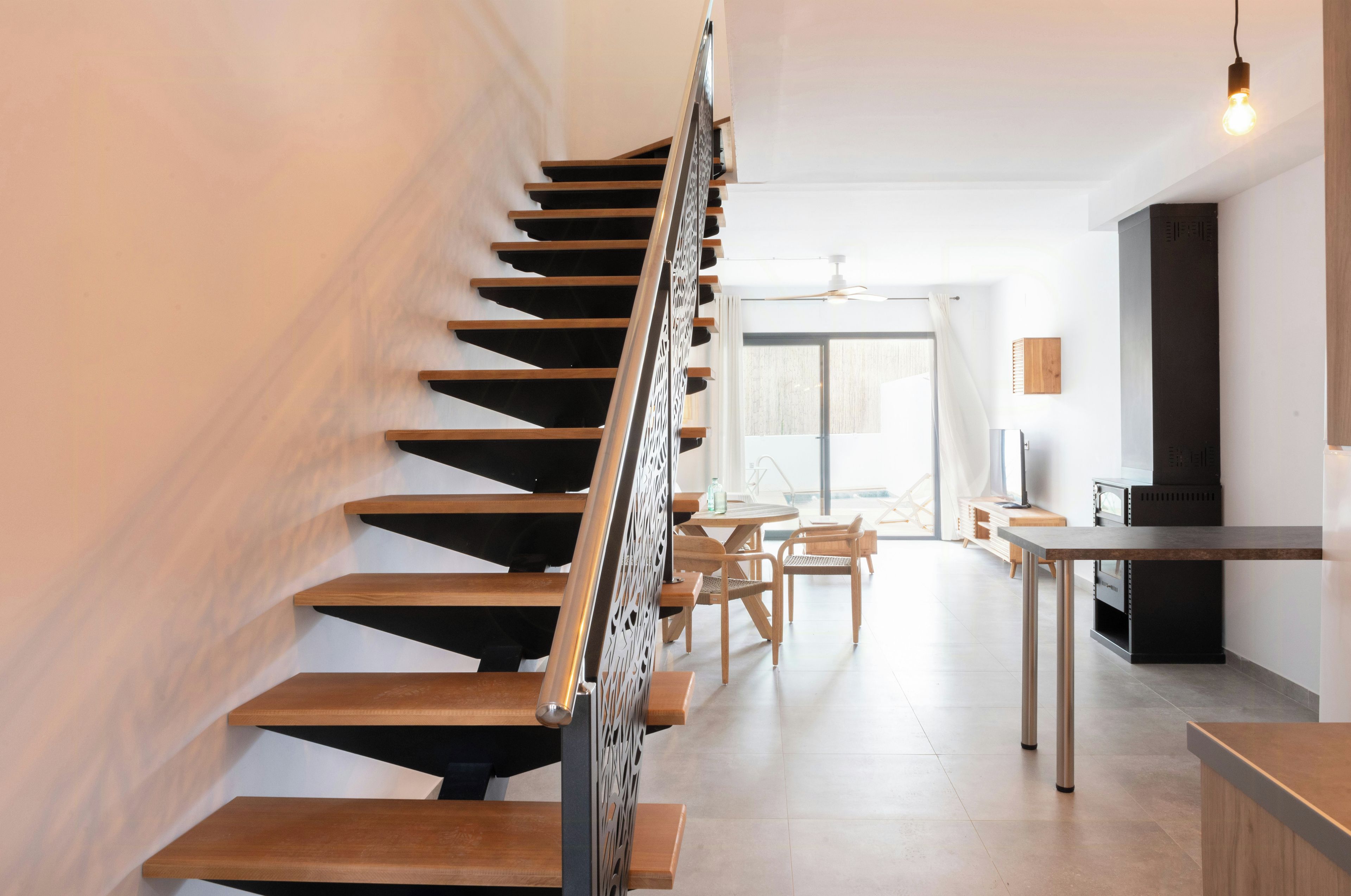 Ein modernes Interieur mit einer Holztreppe, einem Essbereich und einer Küche.