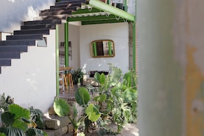 A staircase leading to a room with a green door, a mirror on the wall, and a small table with chairs. - A unique spot in Oaxaca's Historic District. Parks, restaurants, and museums within walking distance. (Oaxaca de Juárez)