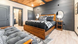 Ein Schlafzimmer mit einem hölzernen Bett, einem Nachttisch, einem Spiegel und einem Teppich.