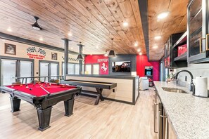 Ein Billardtisch, eine Bar und eine Wand mit rotem Ferrari-Design.