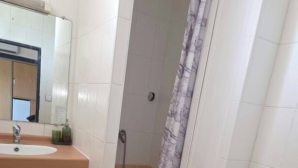 Un baño con inodoro, lavabo y ducha.